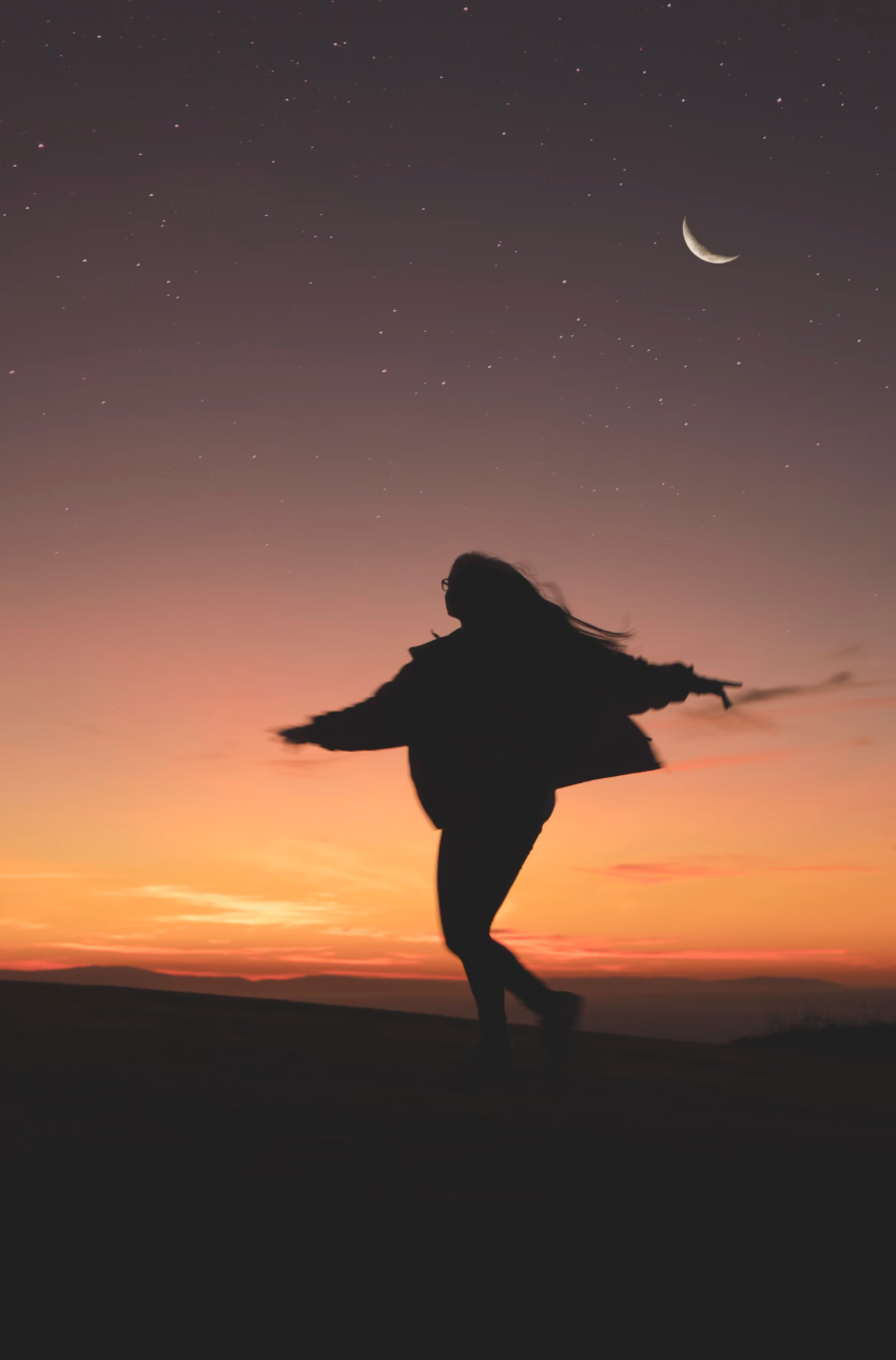 woman dancing under moon sky
